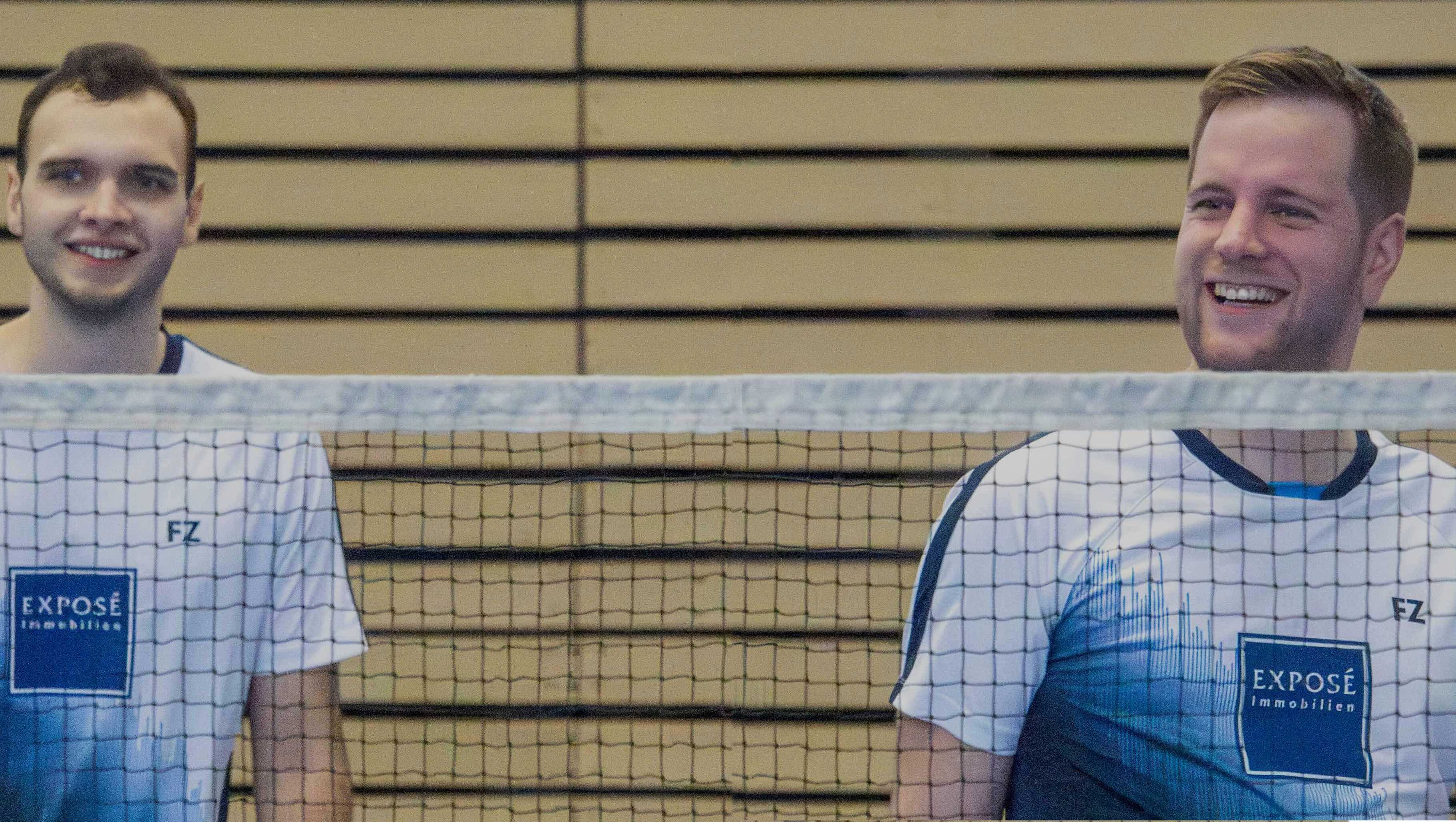 Picture of two players behind a badminton net